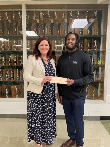 DeAmonte King presents a donation check to Charmayne Polen Assistant Vice Principal of St. Vincent St. Mary High School.